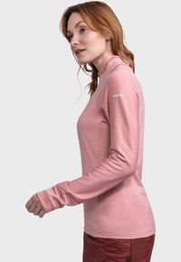 Hellrosa Langarmshirt mit hohem Kragen, gerippter Textur und Daumenlöchern an den Bündchen. Logo auf der rechten Schulter.