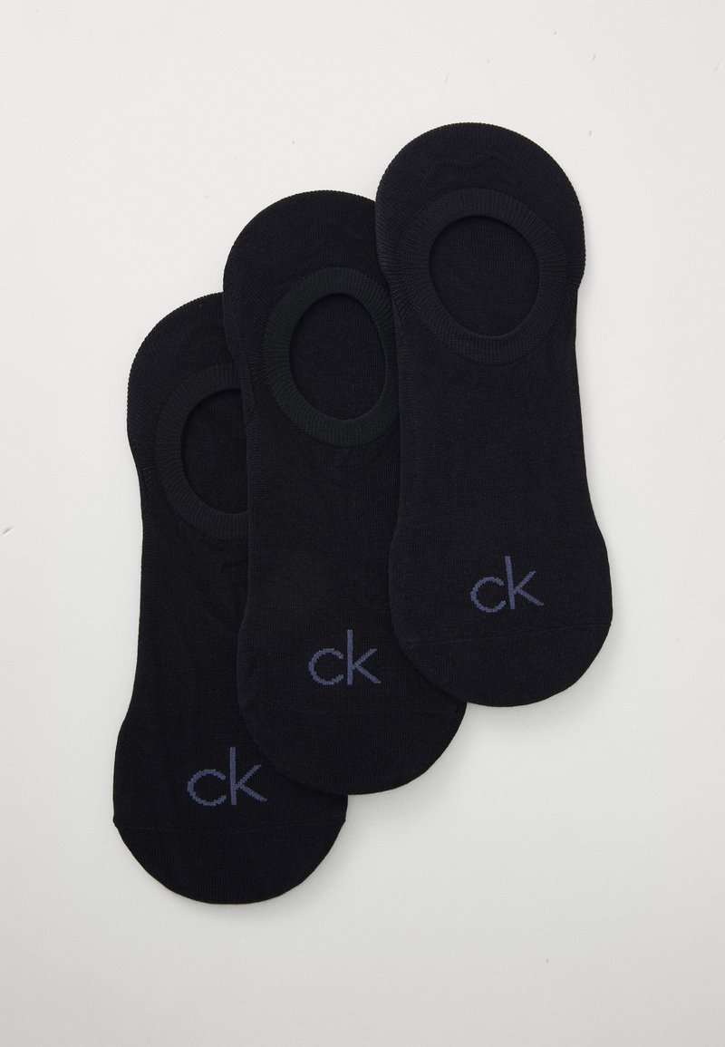 Tres pares de calcetines invisibles de algodón negro con una abertura elástica y un pequeño logo "ck" morado cerca del dedo del pie. Textura suave y lisa.