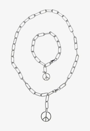 Set srebrne verige in zapestnice z velikim povezovanjem, ki ima na vsakem kosu obesek v obliki simbola miru. Gladka kovinska površina.
