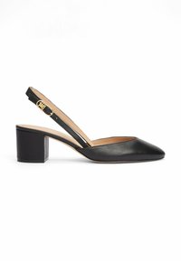 Chaussure slingback en cuir noir avec un bout pointu, un talon moyen en bloc et une boucle en métal doré sur la sangle pour la fermeture.