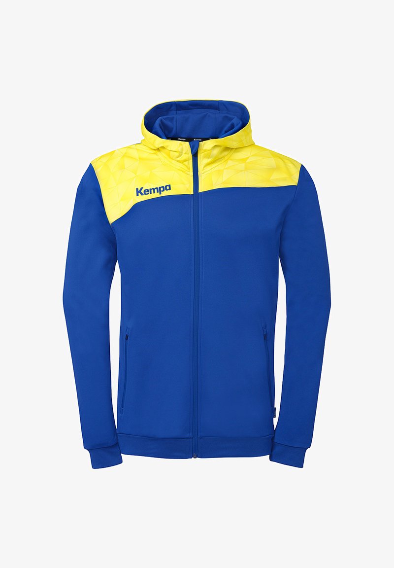 Veste à fermeture éclair bleue avec motif géométrique jaune sur les épaules et la capuche, avec le logo Kempa sur la poitrine gauche.