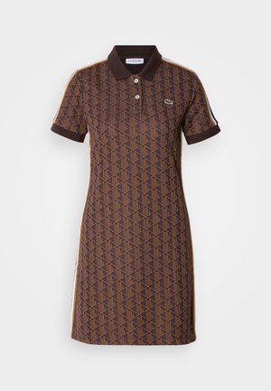Brown polo dress with geometric pattern, short sleeves, and a collared neckline. Features contrasting shoulder stripes and logo detail.