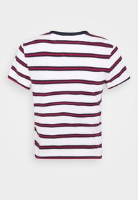 La camiseta de manga corta cortada presenta un tejido blanco con rayas horizontales rojas y azul marino, un cuello acanalado azul marino y un corte relajado.