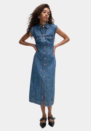 Lys blå denim midi kjole med kapærmer, krave, forreste knaplukning, to brystlommer og en midterslids i kanten.