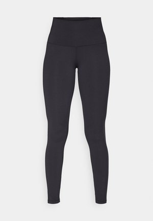 Leggings noirs taille haute fabriqués en tissu extensible, avec une texture lisse, un design long et des détails de couture minimaux.