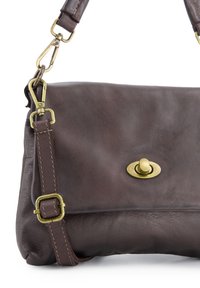 Brown leather handbag with a smooth texture, oval brass toggle clasp, and an adjustable strap featuring gold accents.