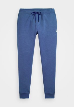 Blue sweatpants made of soft fabric, featuring an elastic waistband with a drawstring, and ribbed cuffs at the ankle. Small logo detail present.