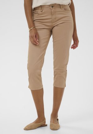 Bézs színű capri nadrág pamut keverékből, karcsúsított szabással, elülső zsebekkel és szegély részletekkel, amelyek lehetővé teszik a mandzsetták enyhe felhajtását.