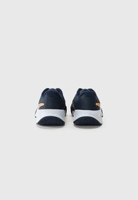 Sportliche Schuhe mit einem Obermaterial aus navy Mesh, weißer Gummisohle und orangefarbenen Akzenten. Das Design umfasst eine strukturierte Rückseite und eine flexible Sohle.