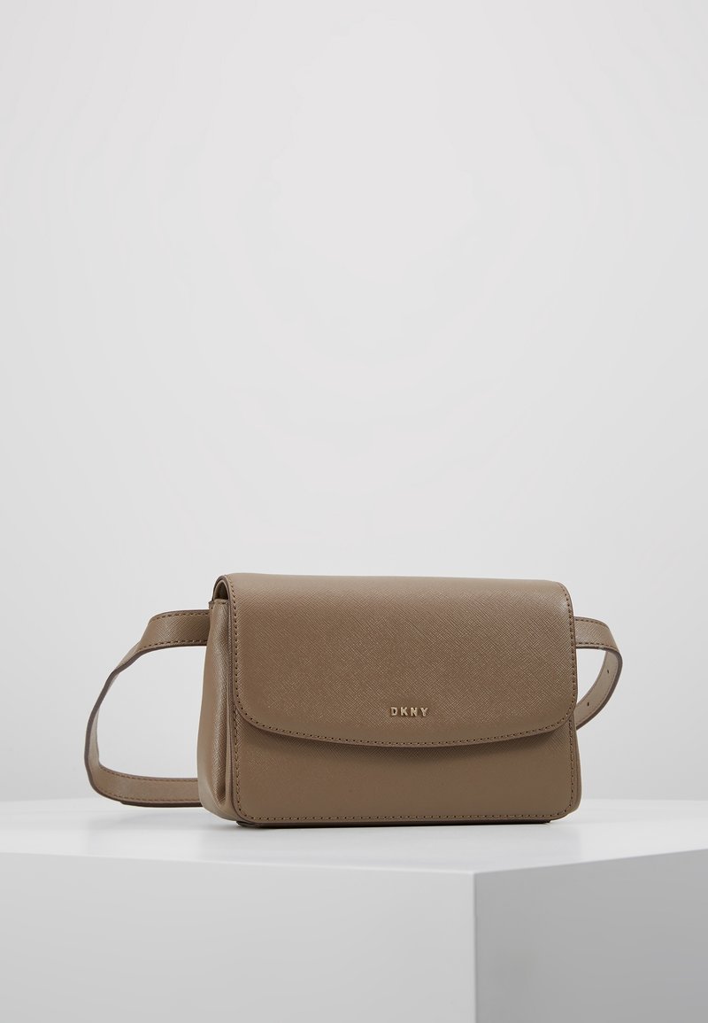 Sac bandoulière DKNY en cuir synthétique camel, avec fermeture à rabat, détail logo et bandoulière réglable. Texture lisse avec un motif subtil.