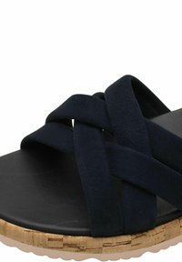 Svarta mockakorssandaler med en korkbas, som har en slät yta och en rund sula.