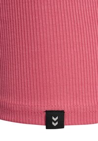Geribbelde roze stof met verticale lijnen; heeft een zwart label aan de zoom met witte chevronpatronen voor merkidentificatie.