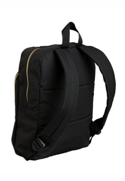 Mochila preta com design acolchoado, alças ajustáveis e detalhes de zíper dourado. Apresenta dois bolsos frontais e uma alça superior para facilitar o transporte.