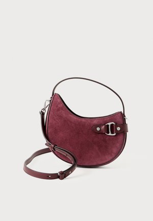 Small burgundy suede handbag with curved shape, leather strap, and silver buckle detail on plain white background.