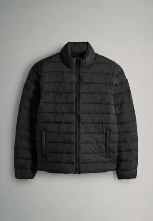 Doudoune noire avec un col haut, des coutures horizontales, une fermeture éclair à l'avant et deux poches latérales. Texture lisse, design léger.
