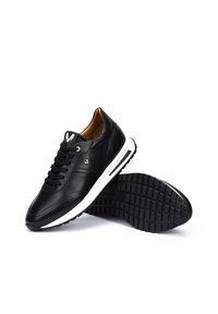 Zwarte leren sneakers met een witte tussenzool, ronde neus, vetersluiting en een gematteerde zwarte rubberen zool. Bevat een logo op de tong.