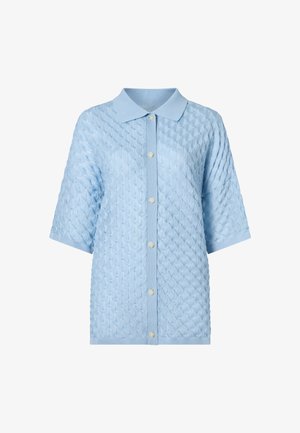 Svetlomodrý krátky pletený kardigán s krátkym rukávom, textúrovaným diamantovým vzorom, špicatým golierom a šiestimi bielymi gombíkmi vpredu.
