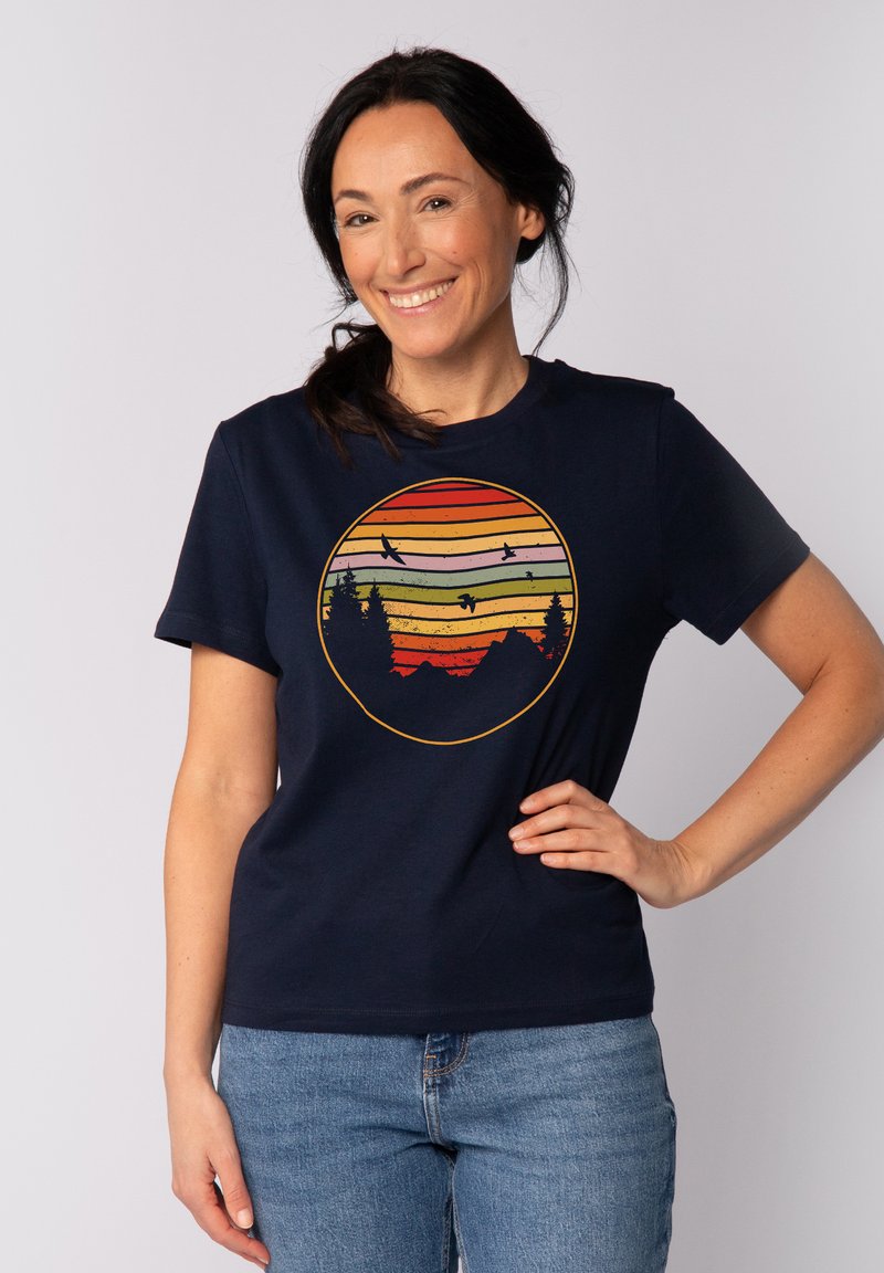 Marineblaue Baumwoll-T-Shirt mit einem runden Grafikdesign und horizontalen Streifen in Orange, Grün und Gelb, das Bäume und Vögel zeigt.
