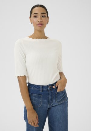 Weißes geripptes Oberteil mit gewelltem Halsausschnitt und kurzen Ärmeln, kombiniert mit blauem Denim-Jeans im High-Waist-Stil mit Gesäßtaschen.