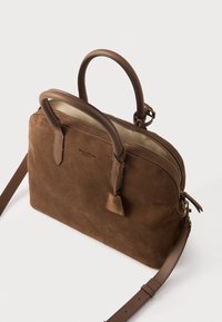 Sac à main en suède marron avec des accents en cuir, deux poignées, une bandoulière amovible et une fermeture zippée. Doublure intérieure lisse.