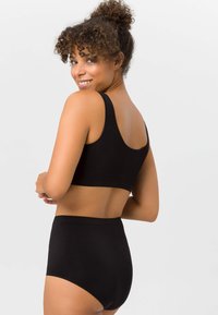 Schwarzes Bralette und hochgeschnittene Unterwäsche aus glattem Stoff, mit einem schlichten Design, breiten Trägern und einer nahtlosen Verarbeitung.