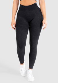 Leggings neri a vita alta realizzati in tessuto morbido con una texture liscia, dotati di una cintura a costine e linee di accento lungo le gambe.