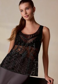 Mustmust kaelusega must beediga tank top, millel on läbipaistev materjal, geomeetrilised mustrid ja ümardatud kaelus. Sile tekstuur koos keerukate beedi detailidega.