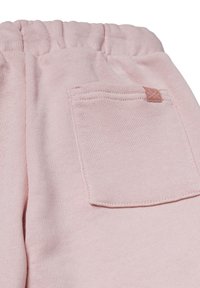 Jasnoróżowe dresy z bawełny z elastycznym pasem w talii, z tylną kieszenią i przeszyciami dla dodatkowego akcentu. Miękka faktura.