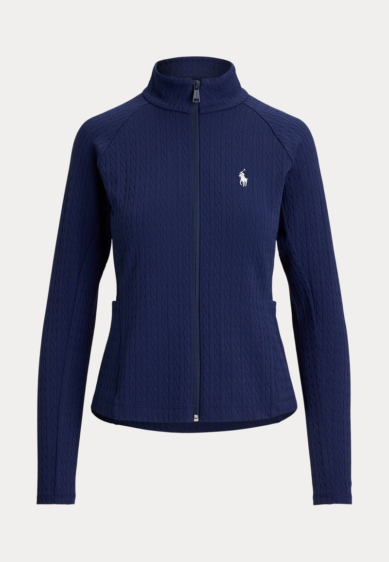 Veste zippée à manches longues bleu marine avec un motif en maille torsadée texturée et un petit logo blanc de joueur de polo sur le côté gauche de la poitrine.