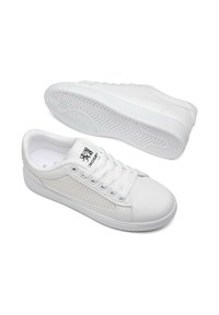 White sneakers featuring a smooth leather upper with mesh accents, flat laces, and a textured rubber sole with a herringbone pattern.