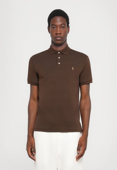 Bruine poloshirt van katoen, met een klassieke kraag, een drie-knopen placket en een geborduurd logo op de linkerkant van de borst. Korte mouwen.