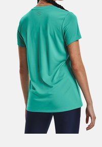 T-shirt atletico leggero verde menta con maniche corte, scollatura rotonda e logo sottile sulla parte superiore della schiena, realizzato in tessuto morbido.