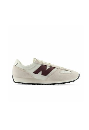 Lavprofileret hvid og beige sneaker med sort sål og bordeaux "N" logo på siden.