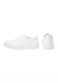 Białe sneakersy wykonane z gładkiej skóry, z okrągłym noskiem, tradycyjnym sznurowanym zapięciem, wyścielonym kołnierzem oraz teksturowaną gumową podeszwą.