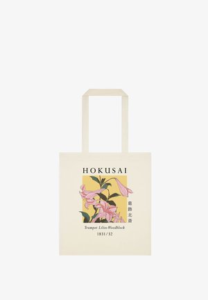 Beżowa torba na ramię z ilustracją różowych lilii trumpetowych i tekstem "Hokusai, Trumpet Lilies Woodblock 1831/32" z przodu.