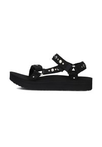 Zwarte platform sandalen met verstelbare banden, zilveren studs en een gestructureerde zool. Het materiaal lijkt duurzaam en zacht te zijn.