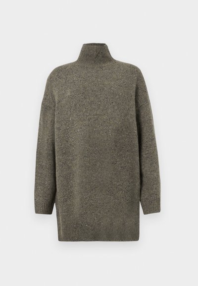 Pull en tricot vert foncé avec un col ribba haut, des manches longues et une coupe décontractée. Tissu texturé avec de subtiles variations.