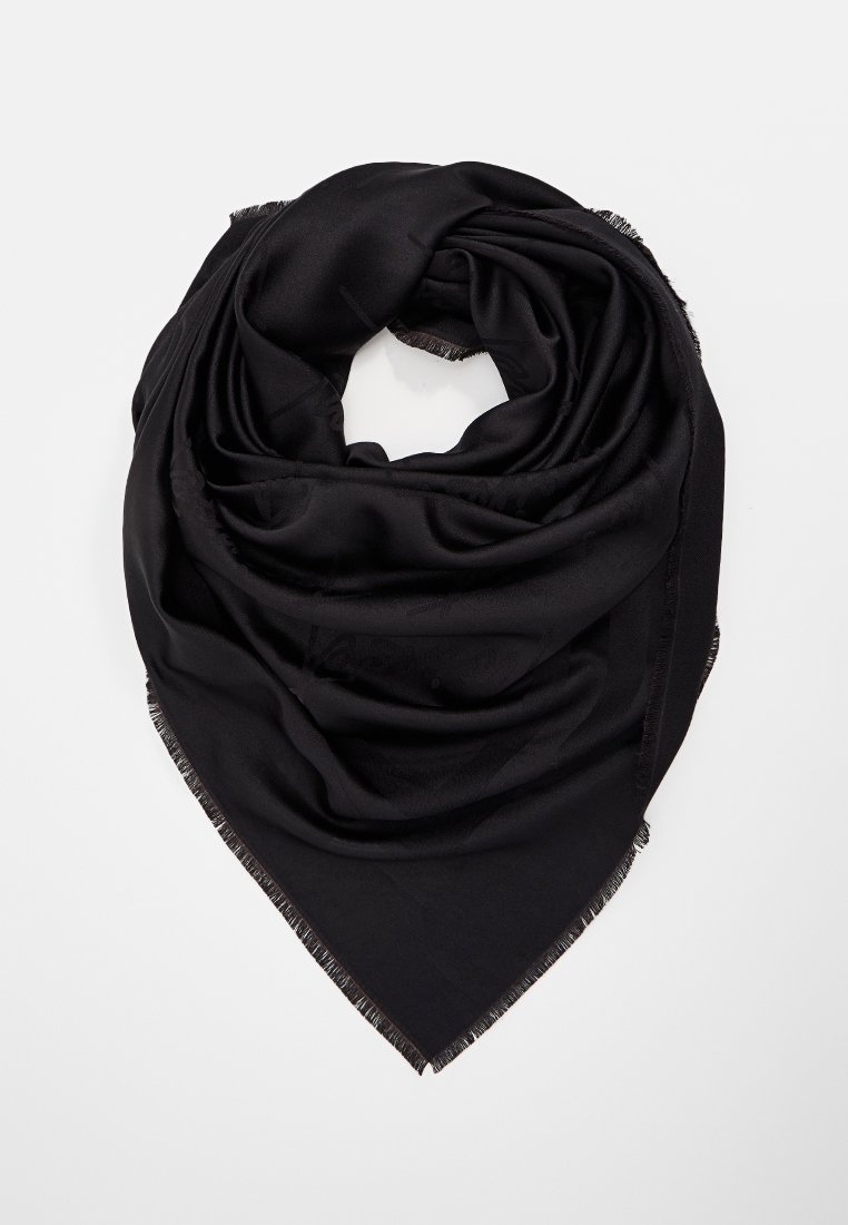 Czarny trójkątny szalik z frędzlami, złożony i ułożony w miękkie warstwy na białym tle.