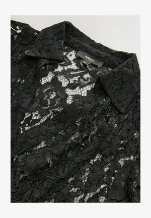 Schwarze Spitzenbluse mit Kragen, die ein florales Muster und eine durchsichtige Textur aufweist. Das Etikett lautet "NEXT." Der Stoff hat aufwendige Details.