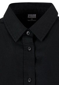 Black button-up shirt with a classic collar. Made of fabric with a smooth texture. Features five black buttons and an interior tag displaying brand information.