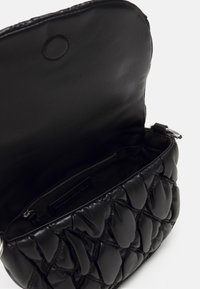 Black, quilted leather shoulder bag with a magnetic flap closure. Interior features a zippered pocket and smooth lining. Silver hardware accents.