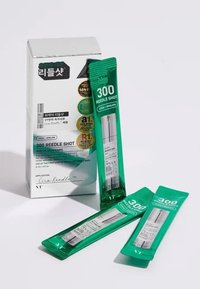 Opakowanie kosmetyków Cica Reedle Shot zawiera srebrne pudełko z trzema zielonymi saszetkami. Saszetki podkreślają cel produktu oraz składniki.