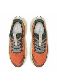 Zapatillas de correr naranjas con una parte superior de malla texturizada, acentos verdes, cordones grises y una suela acolchada de color claro. Incluye detalles reflectantes.