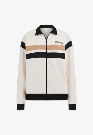Veste zippée en crème, ornée de rayures horizontales noires et beiges. Tissu doux, col et poignets côtelés. Logo "GUESS 1981" sur la poitrine.