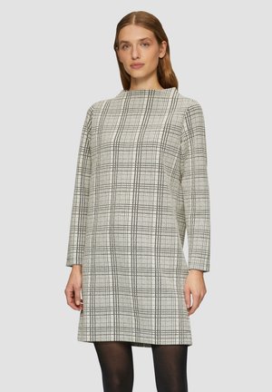 Gekleidetes Kleid in Creme und Schwarz, mit hohem Kragen und langen Ärmeln. Der Stoff hat ein texturiertes Muster und endet oberhalb des Knies.