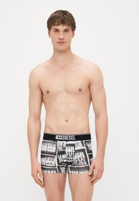 Boxers Diesel em preto e branco apresentam um padrão repetido de logótipos, tecido macio e uma cintura preta contrastante com letras brancas.