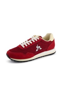 Sneaker in suede rosso e mesh con lacci bianchi, accenti crema e un logo. Presenta una suola imbottita e una superficie texturizzata per una presa migliore.