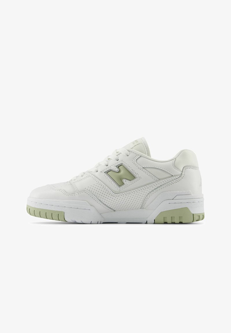 White athletic shoe with perforated leather upper, green accents, padded collar, and textured rubber sole. Chunky, retro-inspired design.