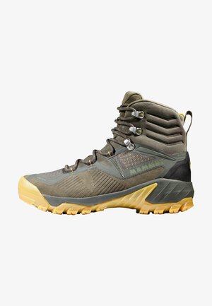 High-ankle hiking boots in olive green with a textured upper, yellow accents, and a rugged, multi-directional tread on a thick sole.