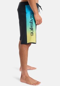 Schwarze Boardshorts mit einem Farbverlauf von Blau zu Gelb am Seitenpanel, ausgestattet mit einem großen Quiksilver-Logo. Hergestellt aus leichtem, schnell trocknendem Material.
